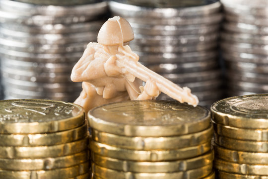 Toy soldier in between stacks of coins