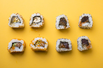 Various kinds of sushi food served on yellow blackground