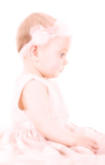 Profile of little girl shot in high key with pink little dress and flower headband
