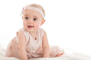 Portrait of little baby girl in pink dress and headband, photo shot against white background