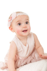 Baby girl sitting on a blanket against white background