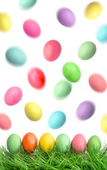 Easter eggs in green grass and flying in the air