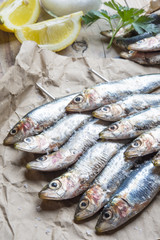 fresh sardines raw fish with coarse salt and thyme on brown pape