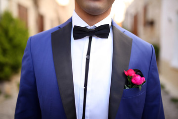 Groom in the wedding blue suit with flowers