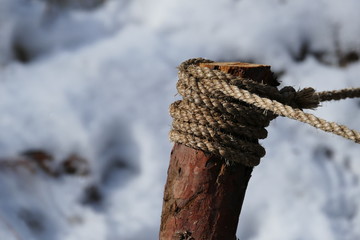 Wood with rope on top and snow background