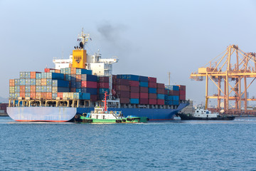 Cargo ship at the port arriving with push boat working