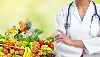 Doctor woman near shopping cart with food.