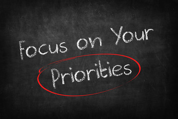Obraz premium focus on your priorities words on Blackboard