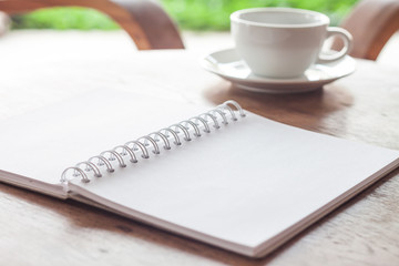 Open blank white notebook with cup of coffee