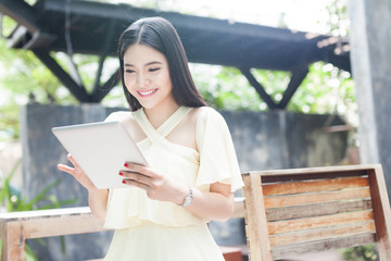 Beautiful Asian woman playing with her tablet