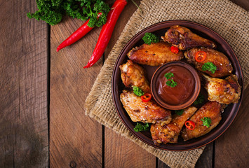 Sour-sweet baked chicken wings and sauce.Top view