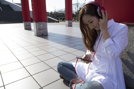 Women are listening to music with the headphones outside