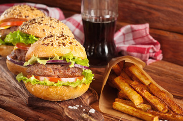 burgers and fries on a dark wooden background