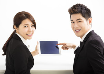 Happy business man and woman holding tablet