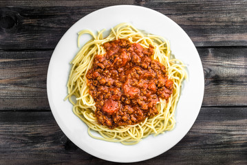 Cooked spaghetti bolognese on white plate.
