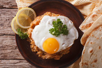 Egyptian breakfast: ful medames with egg close-up. horizontal top view
