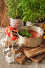 tomato soup with basil in a pot on the marble
