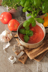tomato soup with basil in a pot on the marble