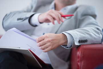 Junger Geschäftsmann im Anzug sitzt im Meeting