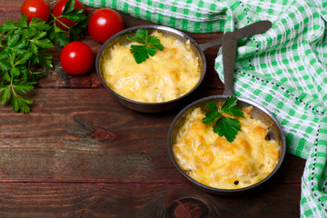 French cuisine. Сhicken with mushrooms baked with cheese in a cocotte