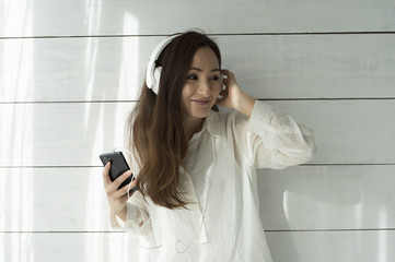 Young women are listening to music with a headphone