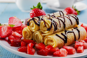 rolled pancakes with strawberries and chocolate breakfast