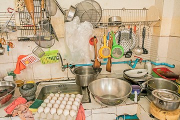 untidy Kitchenware ; Pile of dirty dishes in sink and counter in the kitchen