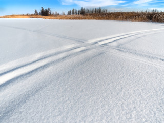 Fototapeta na wymiar snow field with two crossed ski tracks