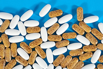 White and yellow pills on a blue