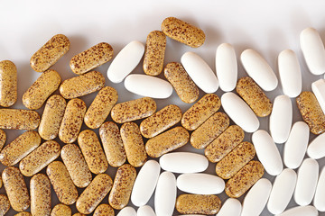 White and yellow pills on a white