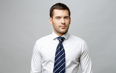 Handsome stylish businessman on grey background