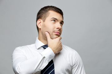 Handsome stylish businessman on grey background