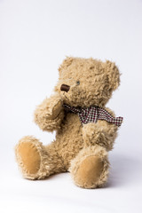 Scruffy teddy bear with copper kettle on white background
