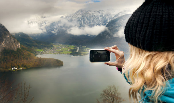 Young beautiful women taking picture of Alps landscape, Hallsatt, Austria