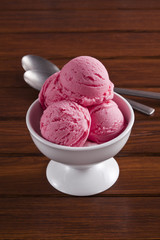 Strawberry ice cream on the brown table.