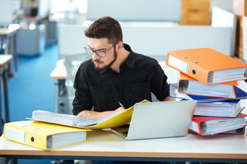 Businessman sitting at the table and reading documents