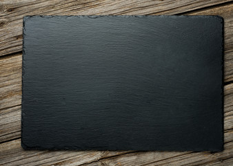 Slate over old wooden background