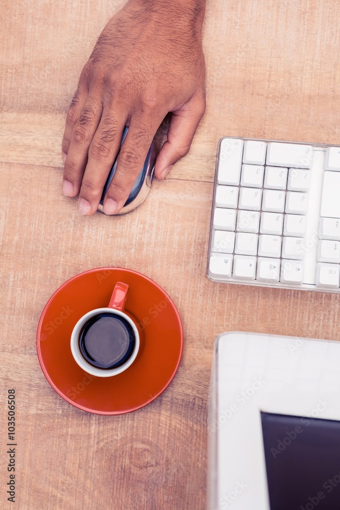 Poster businessman using mouse by coffee cup while working at desk