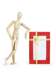 Man stands by the large gift box. Abstract image with a wooden puppet