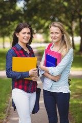 Fototapeta premium Smiling students holding binder 