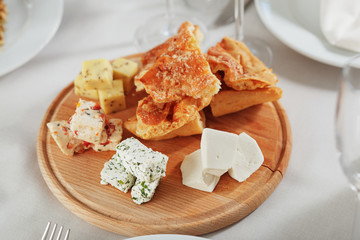 Different types of cheese on wooden plate. Restaurant shot.