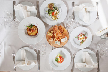 Served table with food on white tablecloth