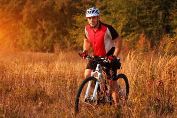 Man is riding a mountain bike in the field