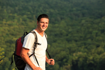 Fototapeta premium Cose up of smiling man with backpack on nature backgound