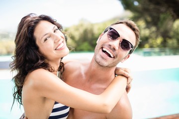 Young couple cuddling each other near pool
