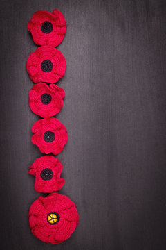 Flower poppy red crocheted from threads on a black background, a