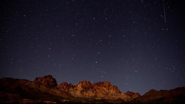 night stars over a desert mountain range - time lapse