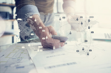Business concept, businessman working with smartphone. Architectural plans on the table. Worldwide...