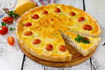 Open pie quiche Lauren with a chicken on a white wooden table