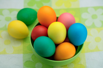 Painted Easter eggs basket on wooden background/ top view